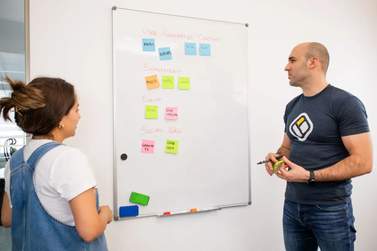 Un equipo se reúne alrededor de una pizarra para definir pautas de contenido, el tipo de planificación del que depende una buena moderación.