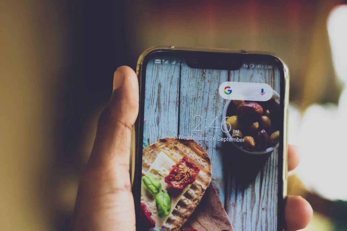 Eine Person fotografiert Essen mit dem Smartphone, die Art von visuellem Content, für die Instagram-Metriken gemacht sind.