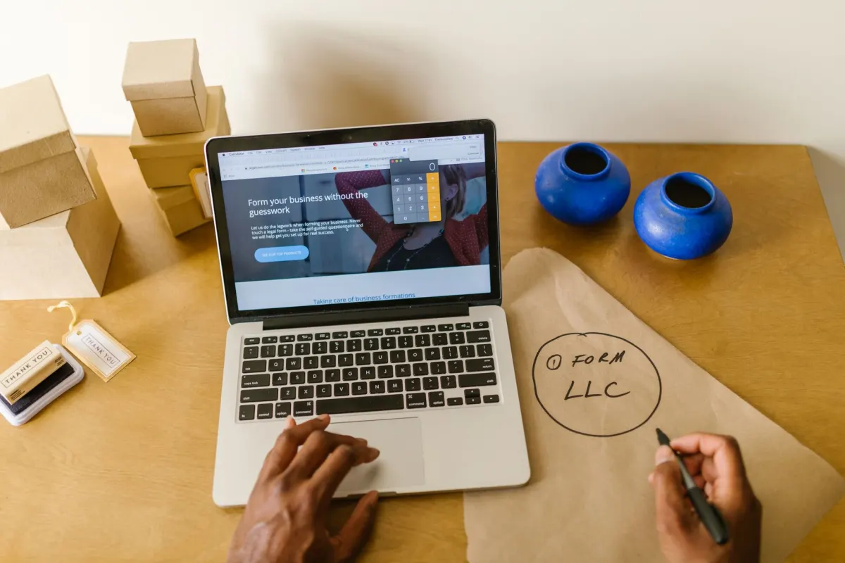 Um pequeno empresario trabalha no laptop, refletindo a disciplina de manter um handle de marca consistente ao longo do tempo.