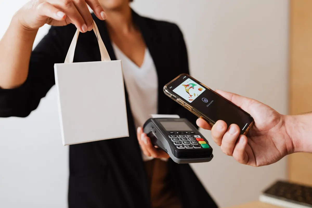 Un acheteur finalise un achat sur son smartphone, représentant l'étape de conversion que les objectifs sociaux cherchent à générer.