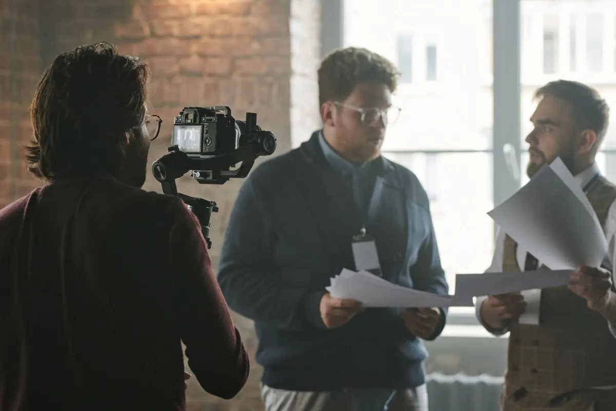 Ein kleines Team filmt Behind-the-Scenes-Aufnahmen im Büro, passend zum unpolierten Stil, der auf Stories und Reels gut funktioniert.