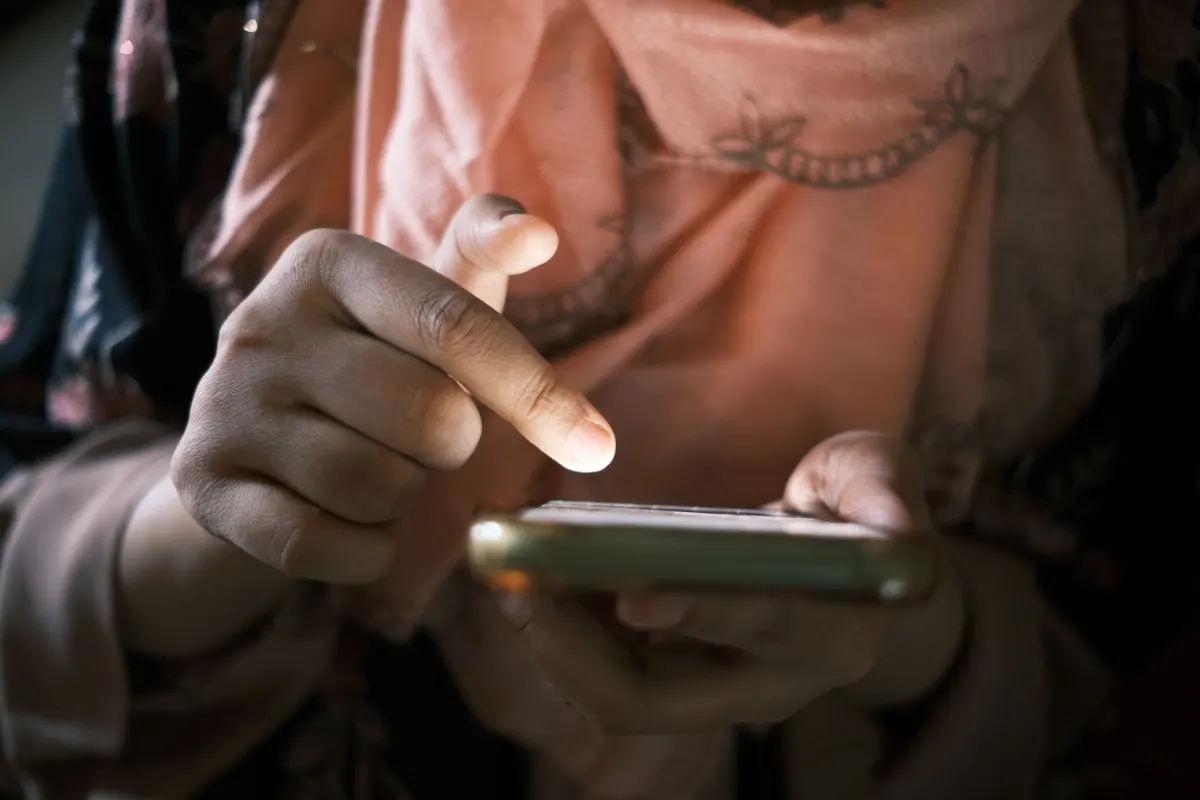 Zwei Hände tippen auf einen Smartphone-Bildschirm und zeigen die Art von schneller Interaktion, die Umfragen und Quizze auslösen sollen.