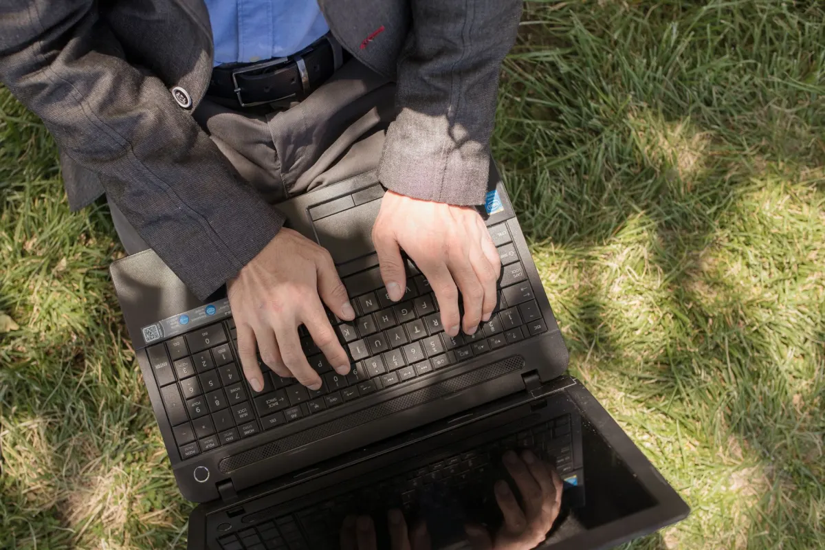 Um dono de loja responde a uma avaliacao de cliente no laptop, ao lado da secao sobre perfis ativos e SEO local.