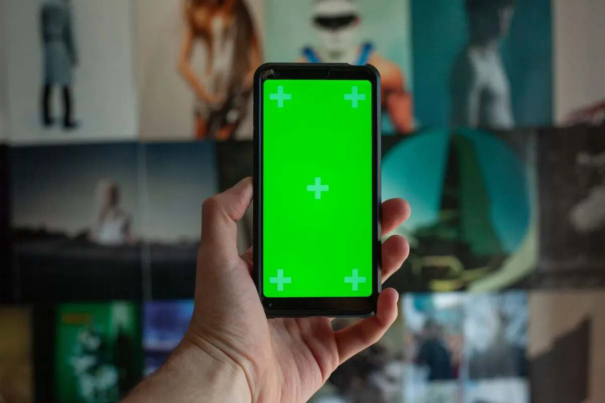 Ein Creator ordnet Fotos auf einem Smartphone in einem Rasterlayout an, bevor er postet. Die visuelle Planung, die in diesem Abschnitt behandelt wird.