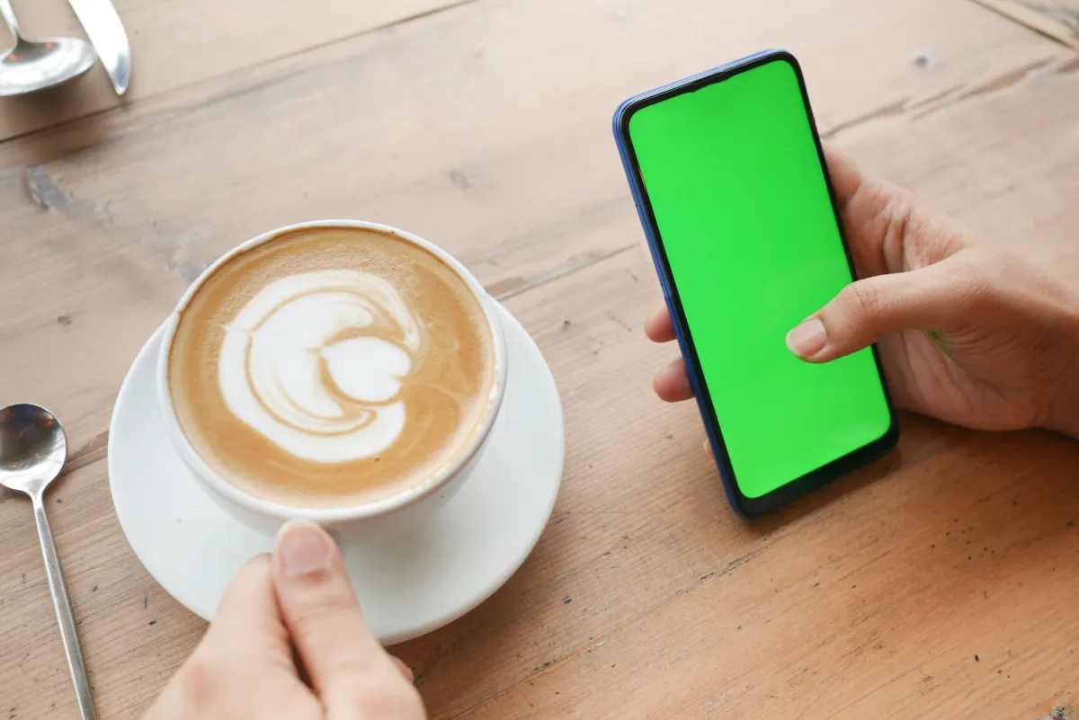 Uma pessoa olha o celular durante o café da manhã, a janela ativa em que as publicações recebem mais atenção.