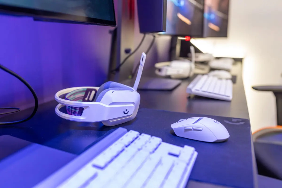 Un gamer porte un casque à un bureau équipé de plusieurs écrans, illustrant le style de bio orienté gaming abordé dans cette section.