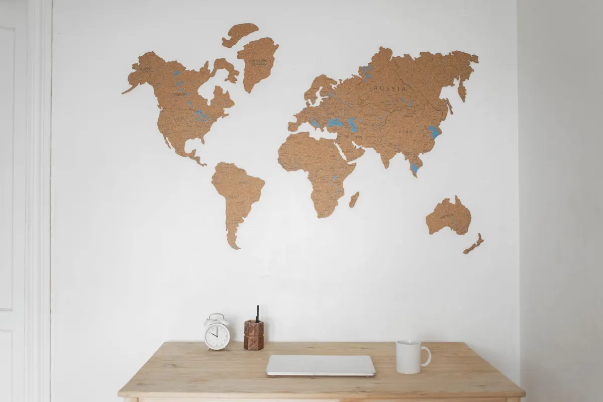 Vários relógios de parede marcando fusos horários diferentes ao lado de um mapa-múndi, remetendo ao agendamento de publicações para um público global.