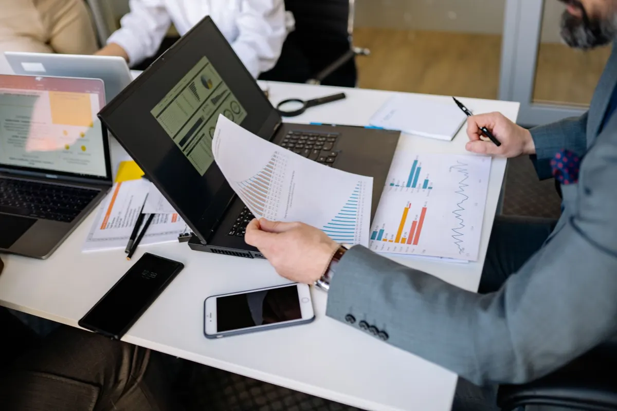 Uma pessoa verifica gráficos de desempenho no celular, relacionado aos dados de audiência do painel de analytics.