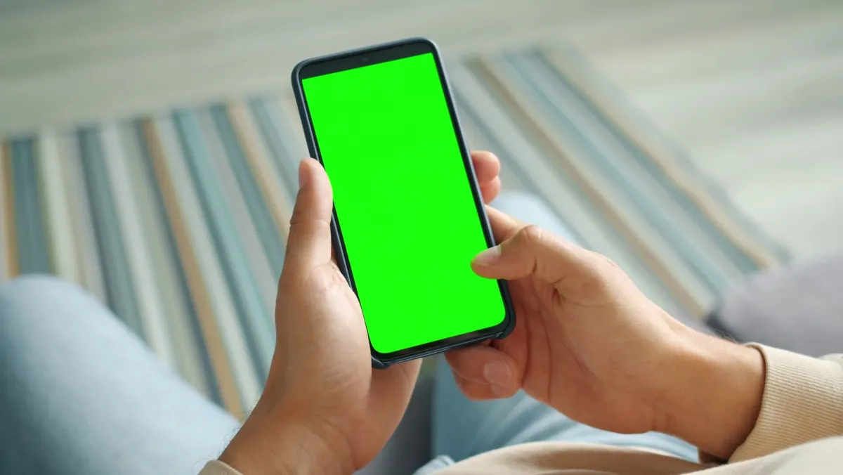 Una persona sostiene un smartphone en vertical, reflejando la orientación de retrato sobre la que está construida la interfaz de TikTok.