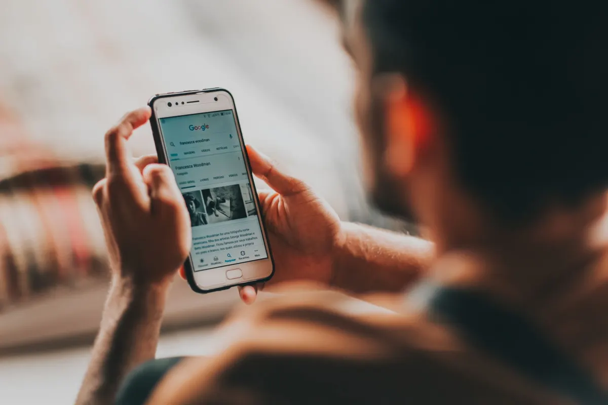 Une personne qui fait défiler son smartphone à la recherche de communautés en ligne pertinentes.