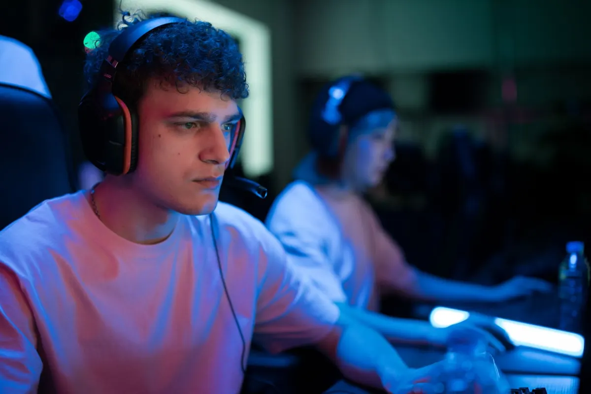 Un jugador con auriculares habla durante una sesión de chat de voz, un entorno donde la plataforma influye en lo que TS probablemente significa.