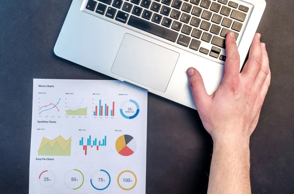 Uma pessoa analisa um gráfico de desempenho em um laptop, o tipo de verificação usada para acompanhar tendências de impressões ao longo do tempo.