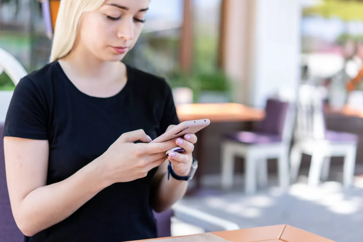 Uma pessoa digitando uma mensagem no smartphone, ao lado da seção sobre aplicativos de mensagens e chat.