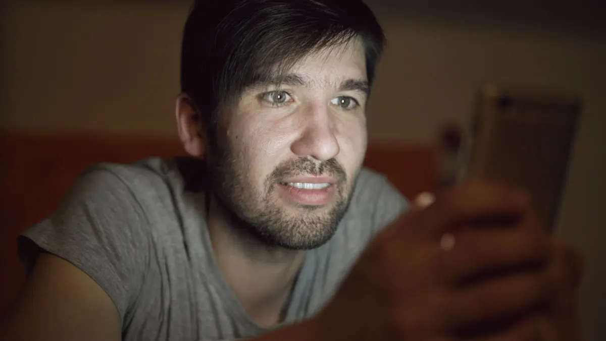 Jemand schaut auf ein Handy, das an einem Ladesymbol hängen bleibt, genau die Art von Aussetzer, um die es in den Troubleshooting-Tipps dieses Abschnitts geht.
