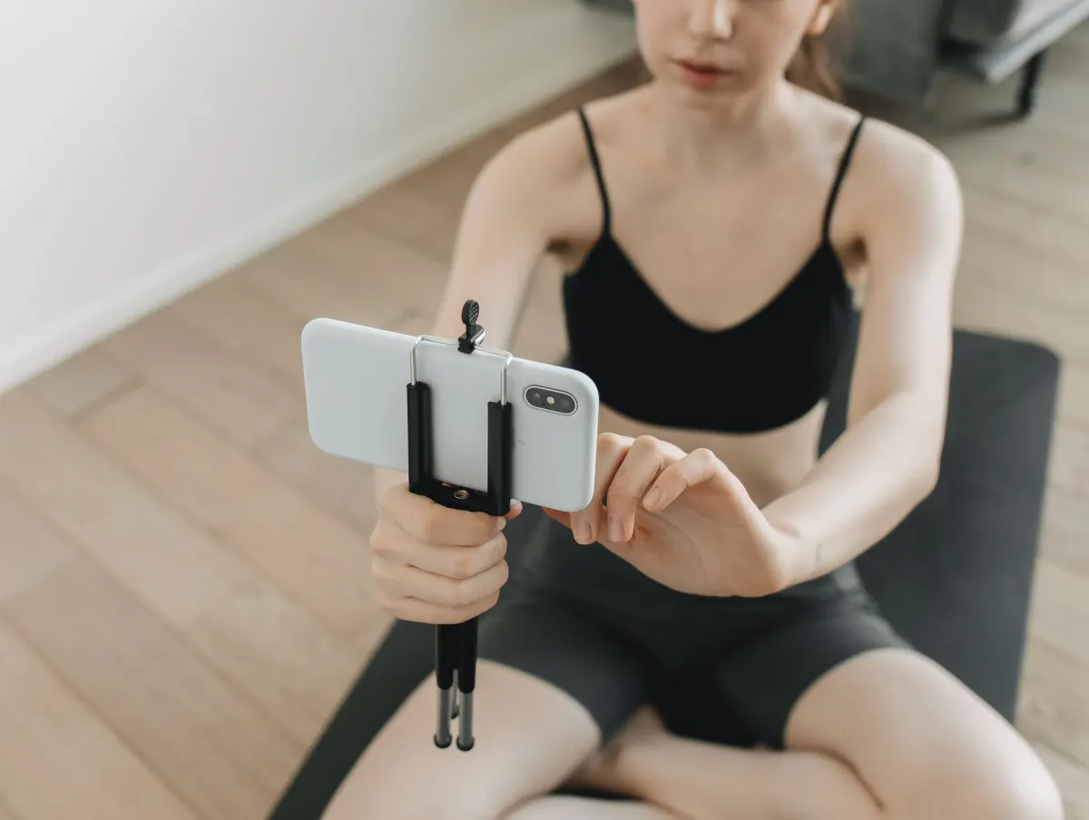 A creator holds a smartphone upright to film a portrait video, the format TikTok is built around.
