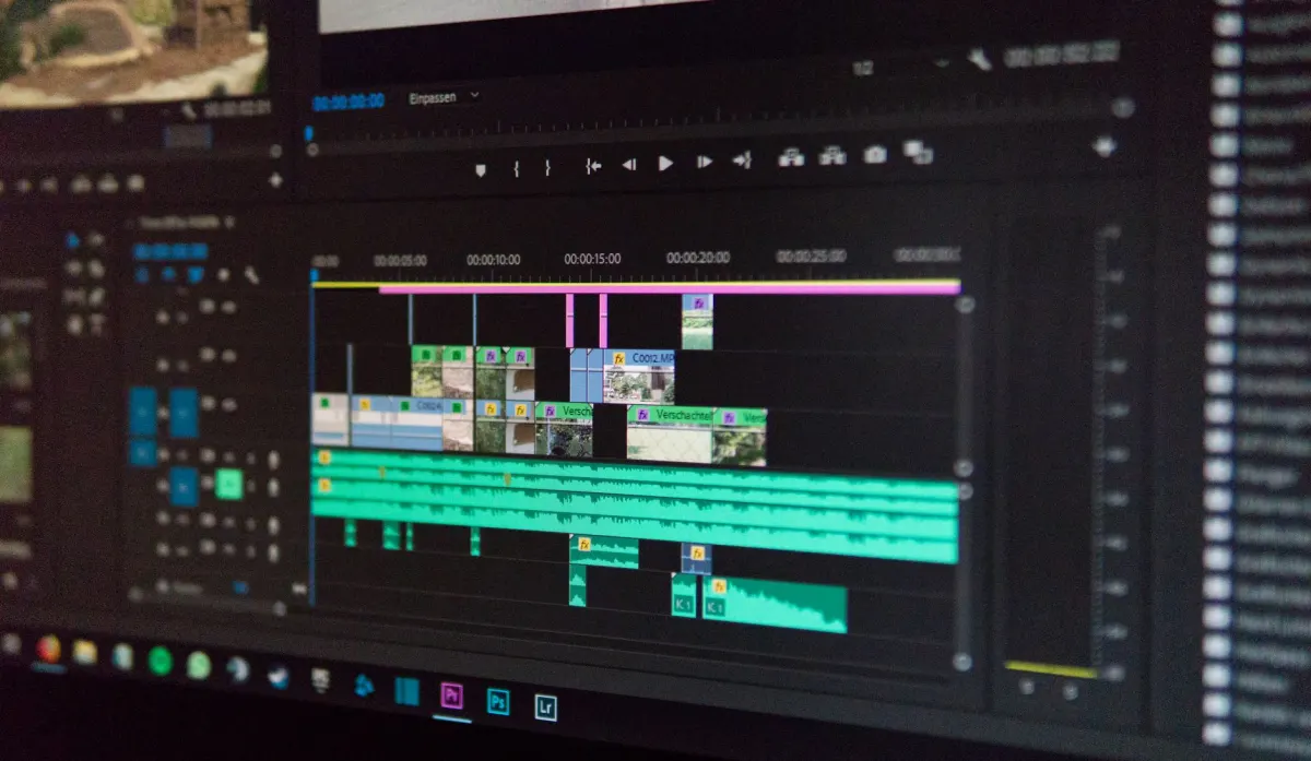 A video editor reviews a project timeline on a monitor before exporting the final file.