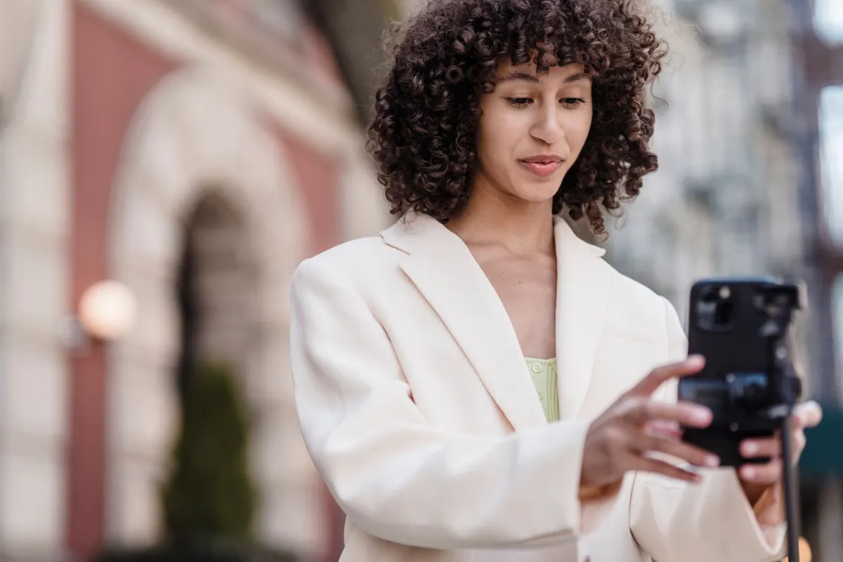 Ein Creator filmt ein vertikales Video mit einem Smartphone auf einem Stativ, stellvertretend für die verschiedenen Videoformate auf Social Media.