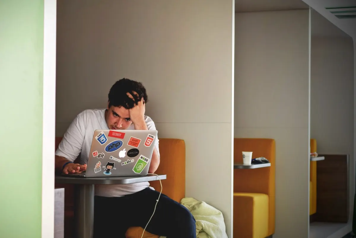 Una persona mira una pantalla de laptop con expresión preocupada, reflejando la cautela necesaria antes de gastar un presupuesto en contenido de bajo rendimiento.