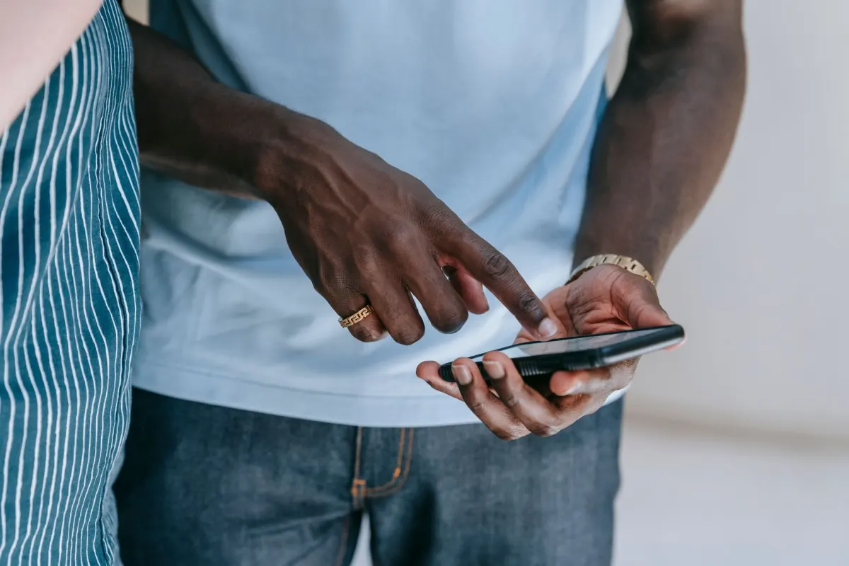 Uma mão rola um feed no celular, mostrando como o mesmo espectador pode ver uma publicação várias vezes.