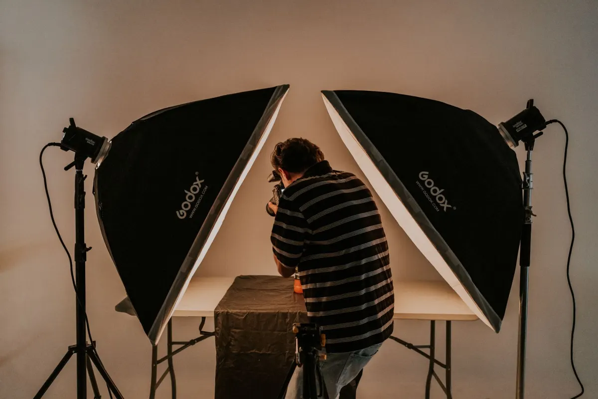 Un fotógrafo toma fotos de producto en un estudio, junto al consejo sobre usar creatividad de alta calidad en los anuncios.