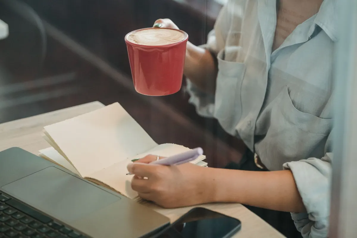 A woman reviewing notes and her phone, reflecting how advertisers study customer feedback before writing ad copy.