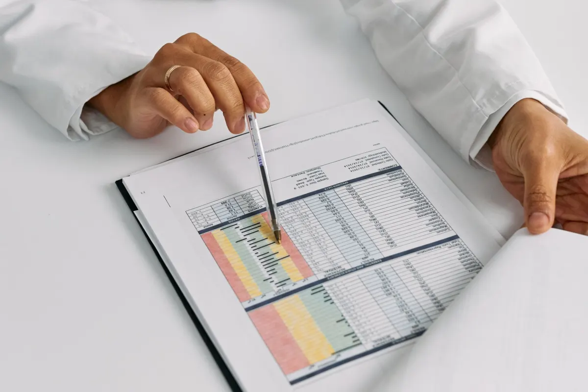 Un investigador revisa una revista médica en un escritorio, en línea con las fuentes creíbles que debe citar el contenido YMYL.
