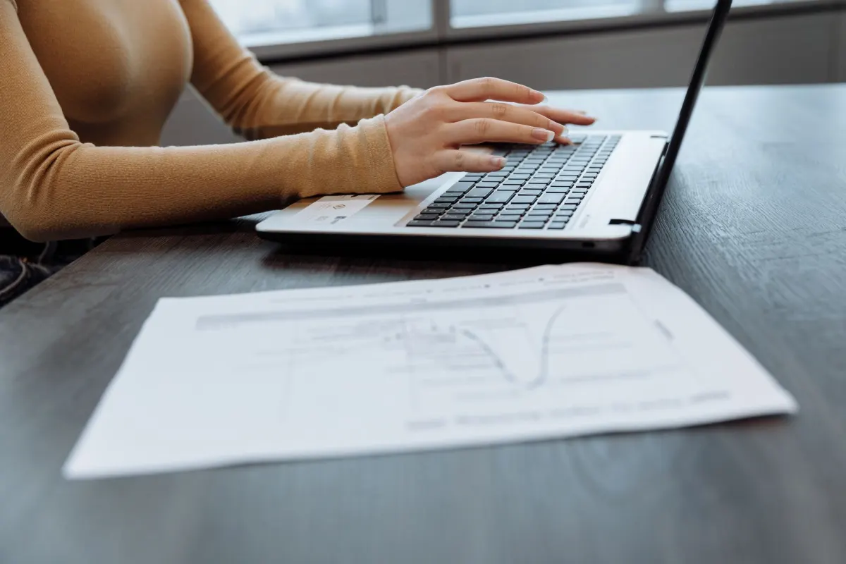 Eine Person tippt auf einer Laptop-Tastatur, das zeigt den Moment, in dem eine Beschreibung geschrieben und gegen ein Längenlimit geprüft wird.