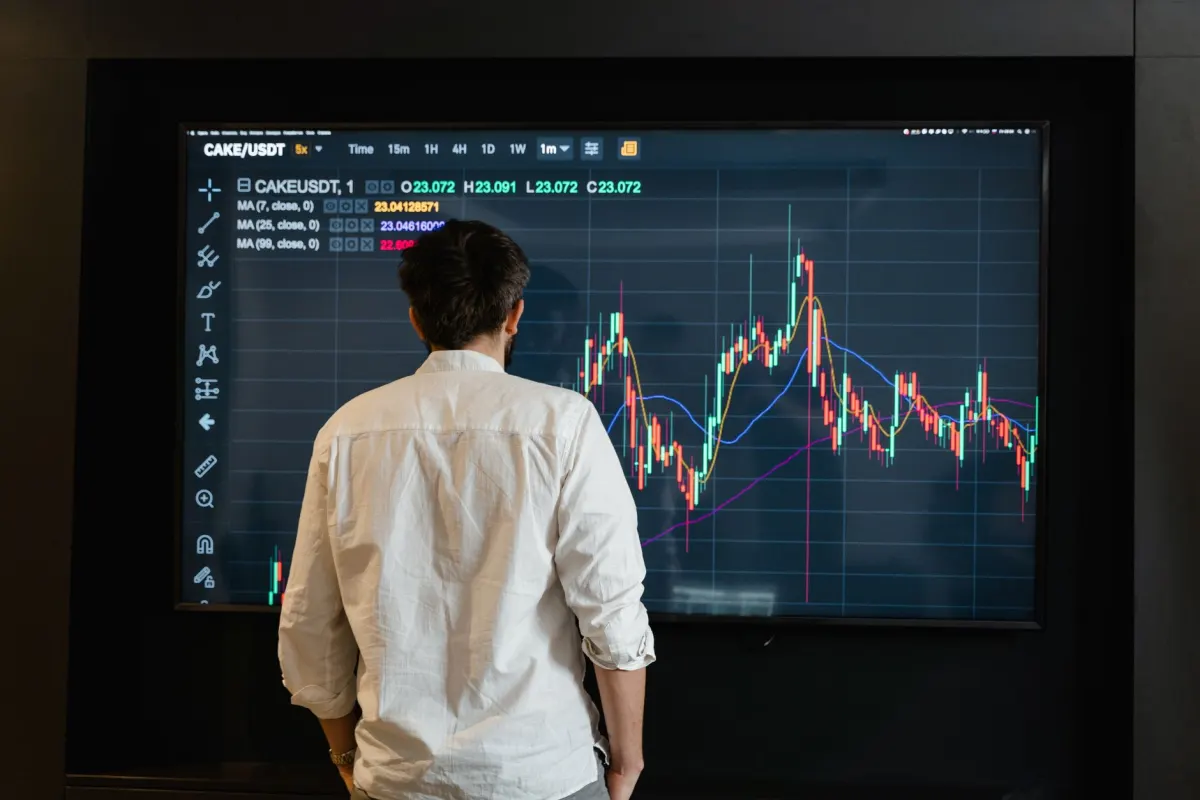 Un especialista en marketing revisa gráficos de rendimiento en un monitor mientras compara herramientas.