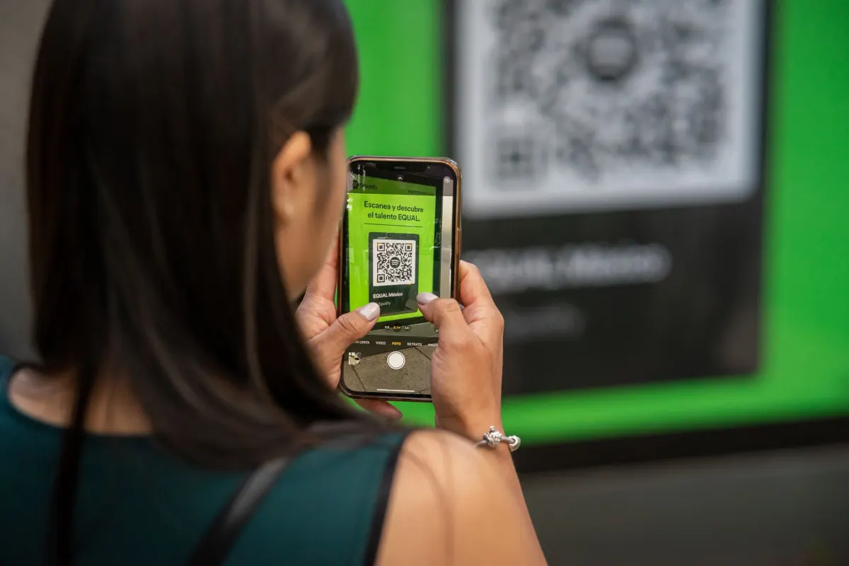 A person scans a QR code on their phone, similar to connecting a messaging channel during setup.