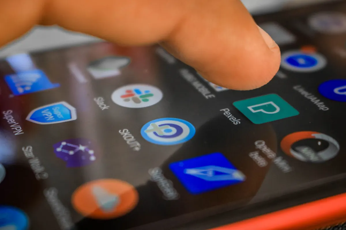 A hand checking a phone notification during a team meeting, the kind of quick glance that surfaces a newly flagged issue.