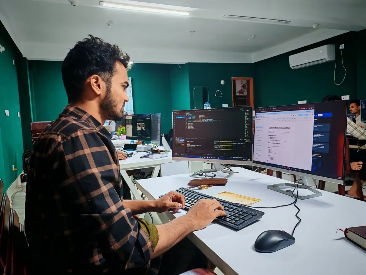 Un desarrollador trabaja con dos monitores, en línea con los flujos de trabajo agénticos de este apartado.