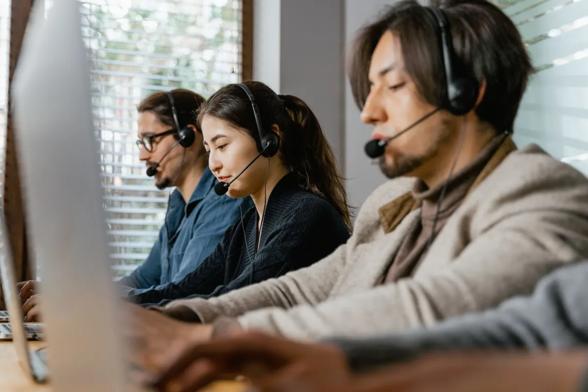 Un agent du support porte un casque à son bureau, en lien avec la section sur la communication et le support.