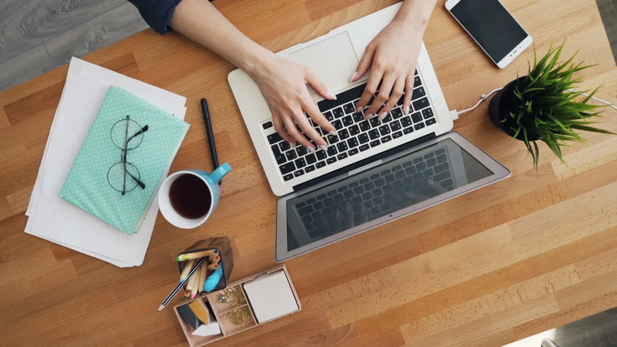 Une personne tape sur un ordinateur portable à son bureau, illustrant l'étape de déploiement d'une instance.