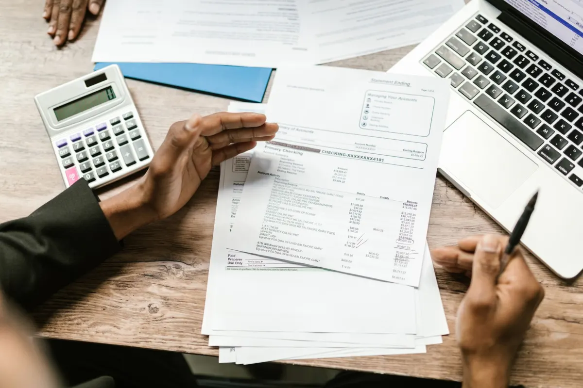 Una laptop y una calculadora sobre un escritorio representan la comparación de costos entre distintos modelos de IA.