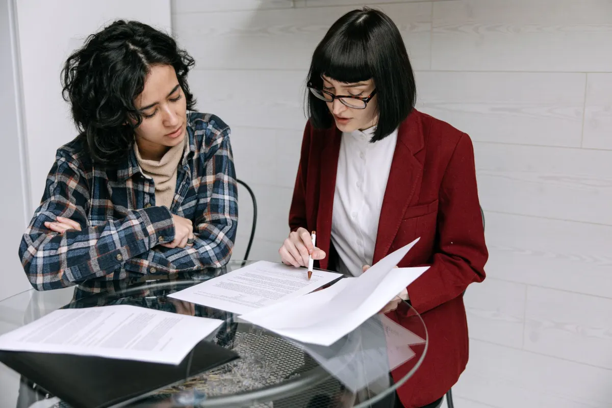 Two people review a contract at a table, the kind of due diligence questions to ask an analytics vendor.