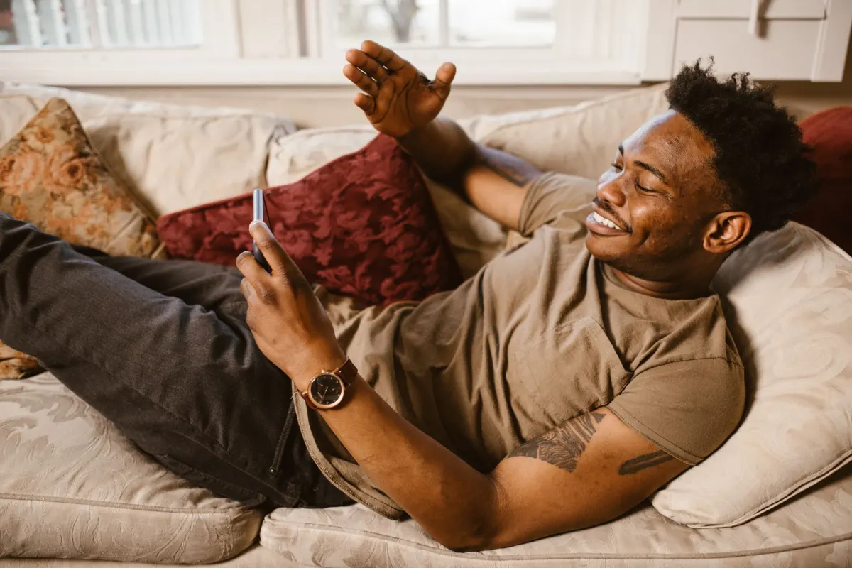 A visitor watches a video on a phone in a relaxed setting, the kind of active foreground engagement GA4's engagement time counts even without a second click.