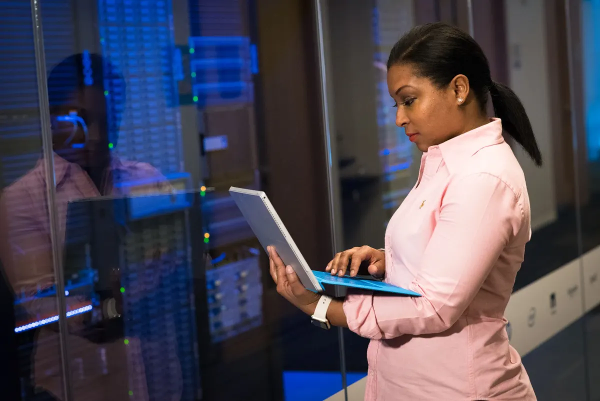 A network engineer manages server racks and cables in a data center, the kind of infrastructure teams use to control what tracking data leaves their domain.