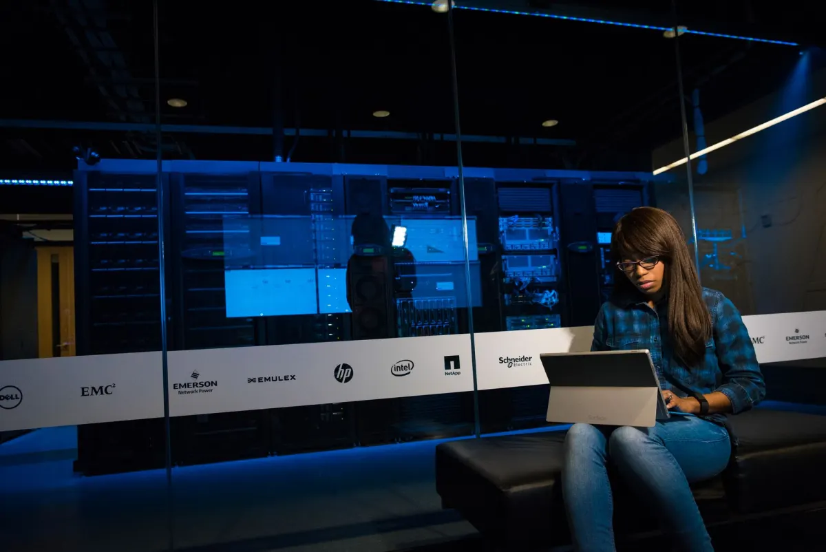 A developer works at a terminal near server racks, reflecting the self-hosting and API work behind open-source analytics.