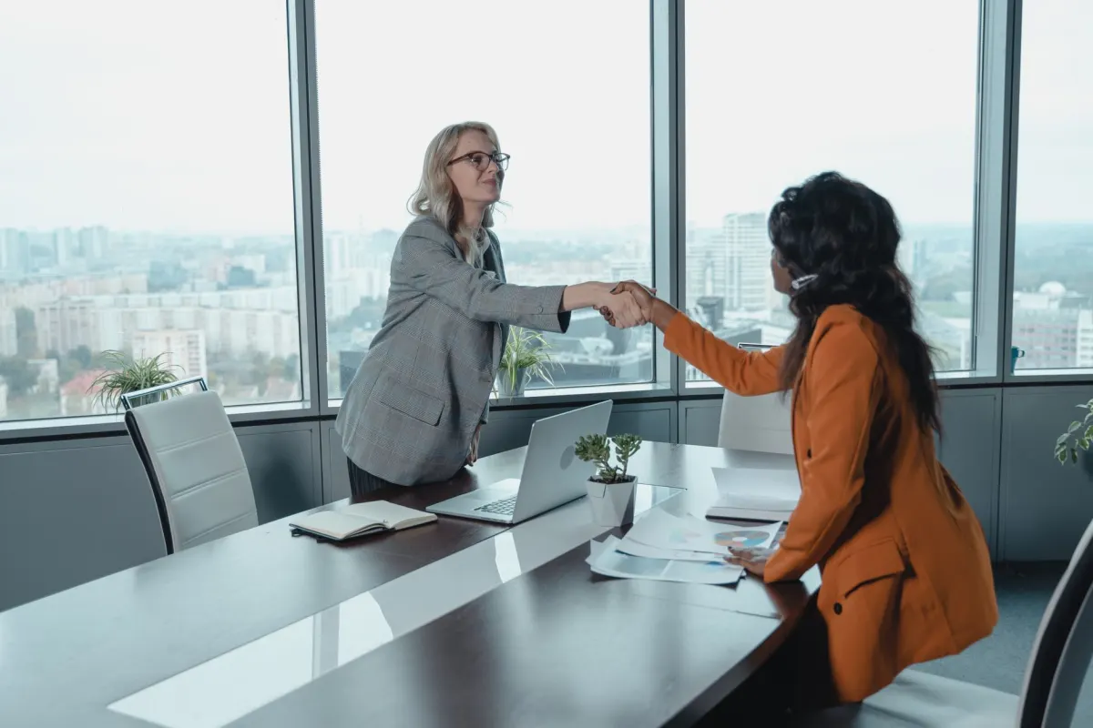 Two colleagues shake hands in an office, representing two companies agreeing to share responsibility as joint controllers.