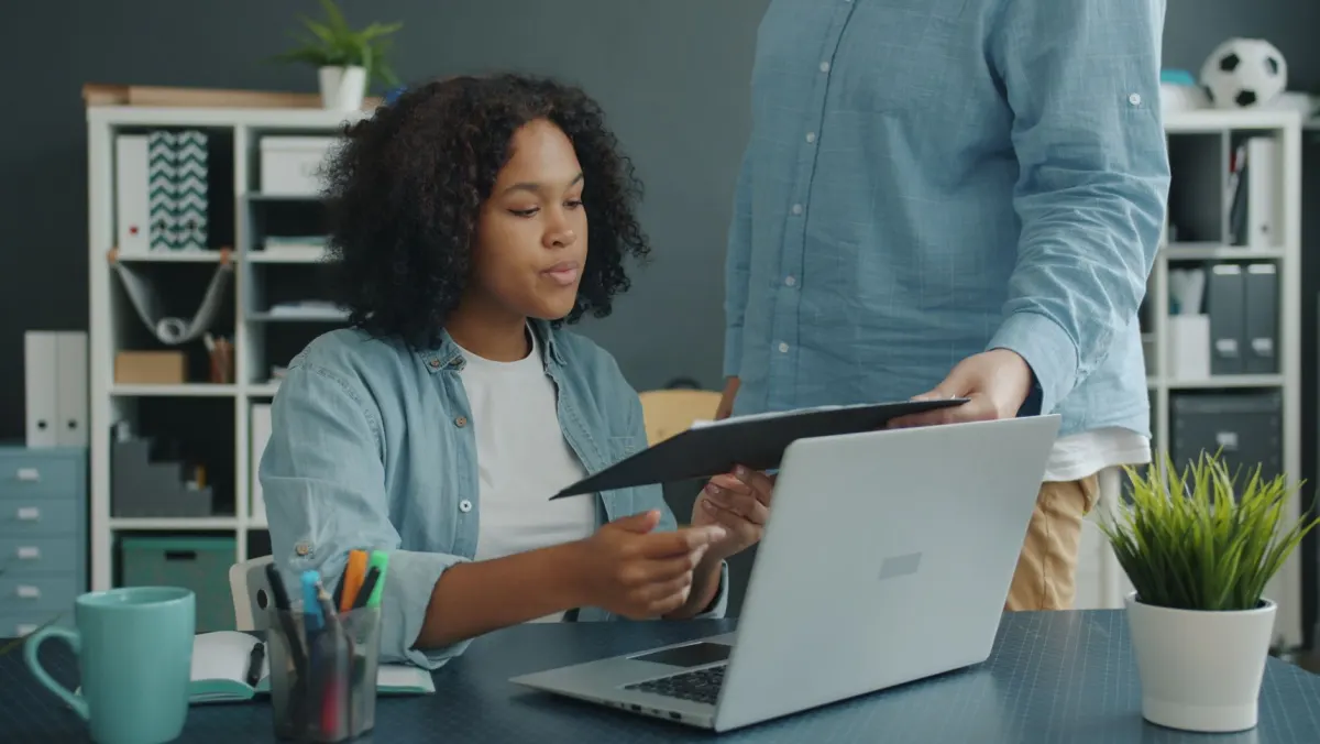 Un pequeño equipo revisa documentos junto a un portátil, reflejo del trabajo de auditoría que hacen las empresas para mapear y limitar la recopilación de datos.