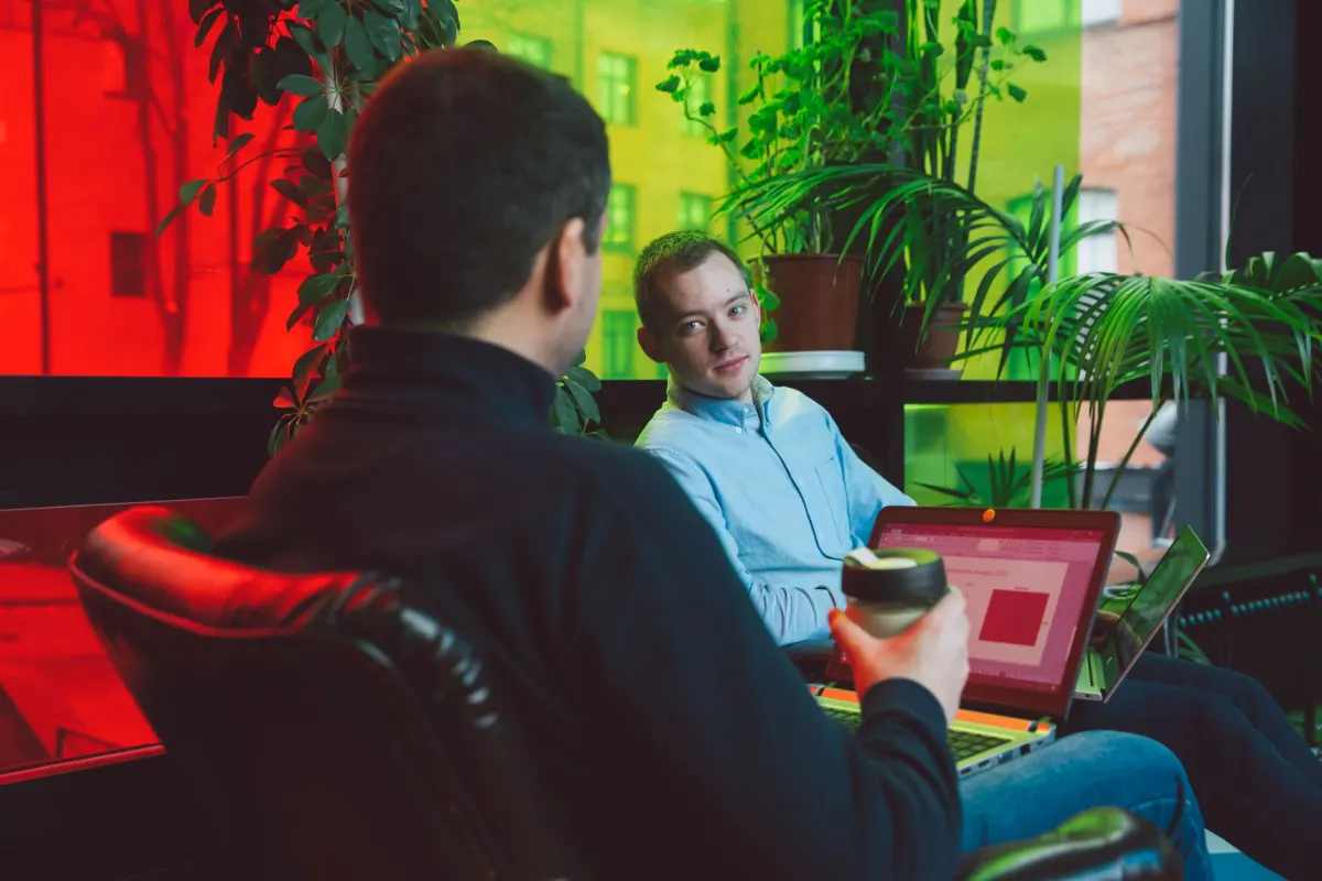 Two colleagues look at a laptop screen together during a meeting, next to the section on whether Webflow Analyze covers a team's full analytics needs.