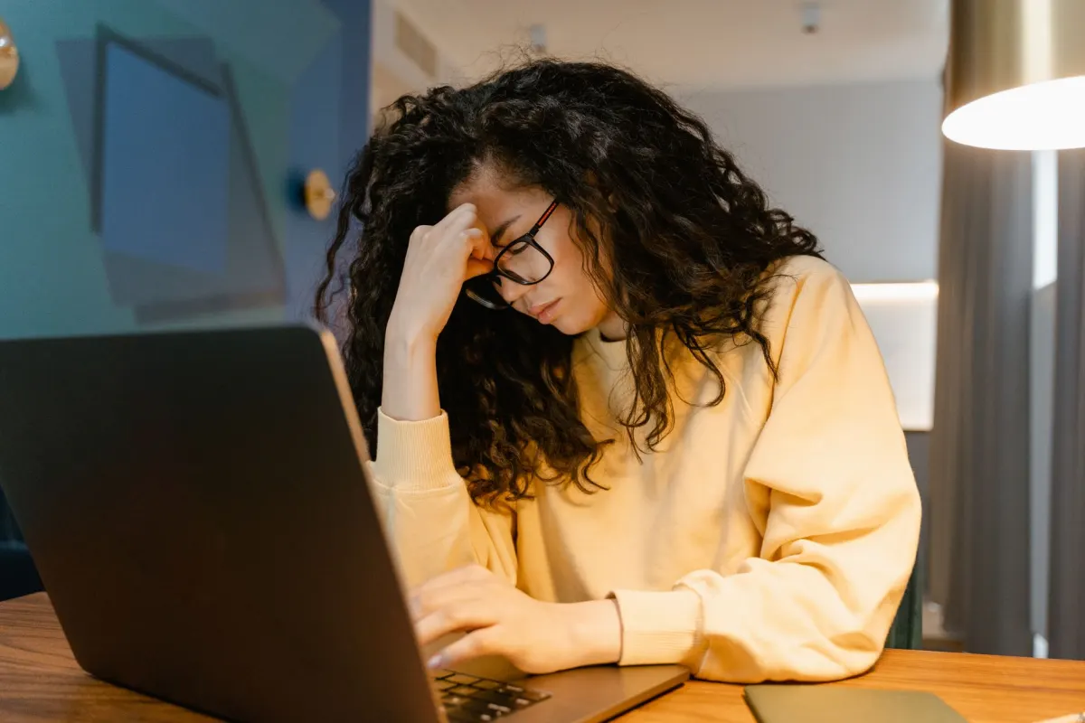 Eine Person beugt sich mit gerunzelter Stirn zum Laptop-Bildschirm, der Blick von jemandem, der eine Sitzungsaufzeichnung prüft, um zu sehen, wo eine Seite Besucher verliert.