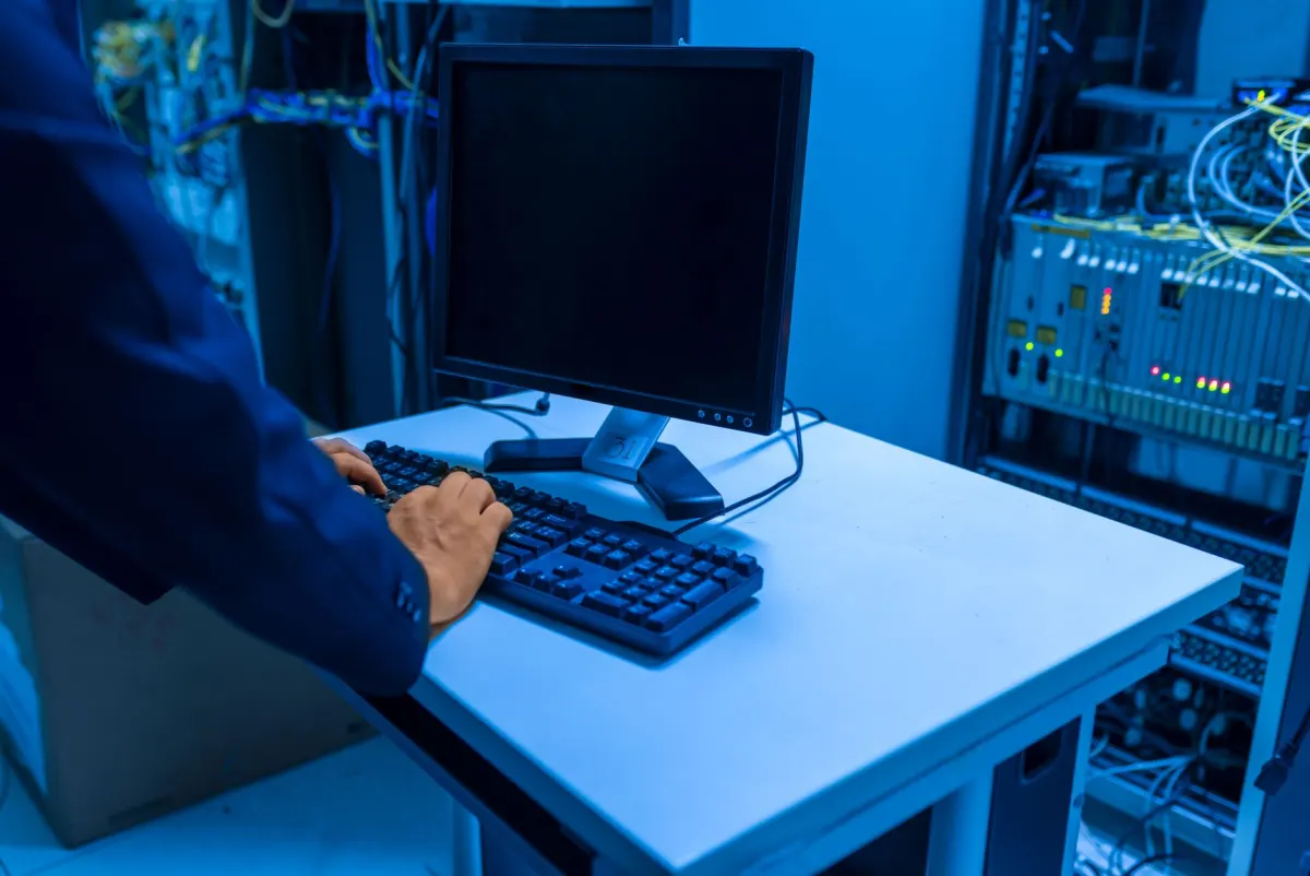 Un technicien surveille des baies de serveurs dans un centre de données, illustrant comment le balisage côté serveur achemine les données publicitaires via la propre infrastructure d'une entreprise.