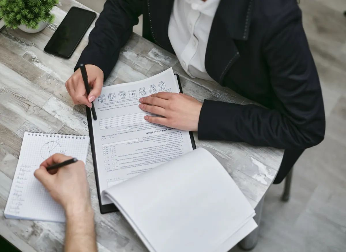 Une personne vérifie une liste de contrôle papier à son bureau, représentant la discipline consistant à documenter le nom, l'objectif et l'expiration de chaque cookie dans un inventaire.