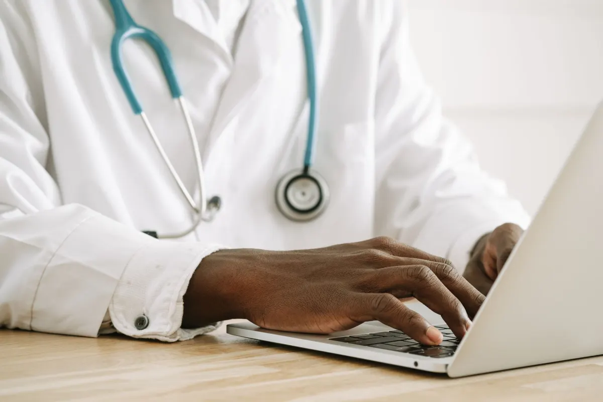 Uma médica insere dados em um computador em uma clínica, uma visita rotineira que gera dados de navegação que merecem proteção.