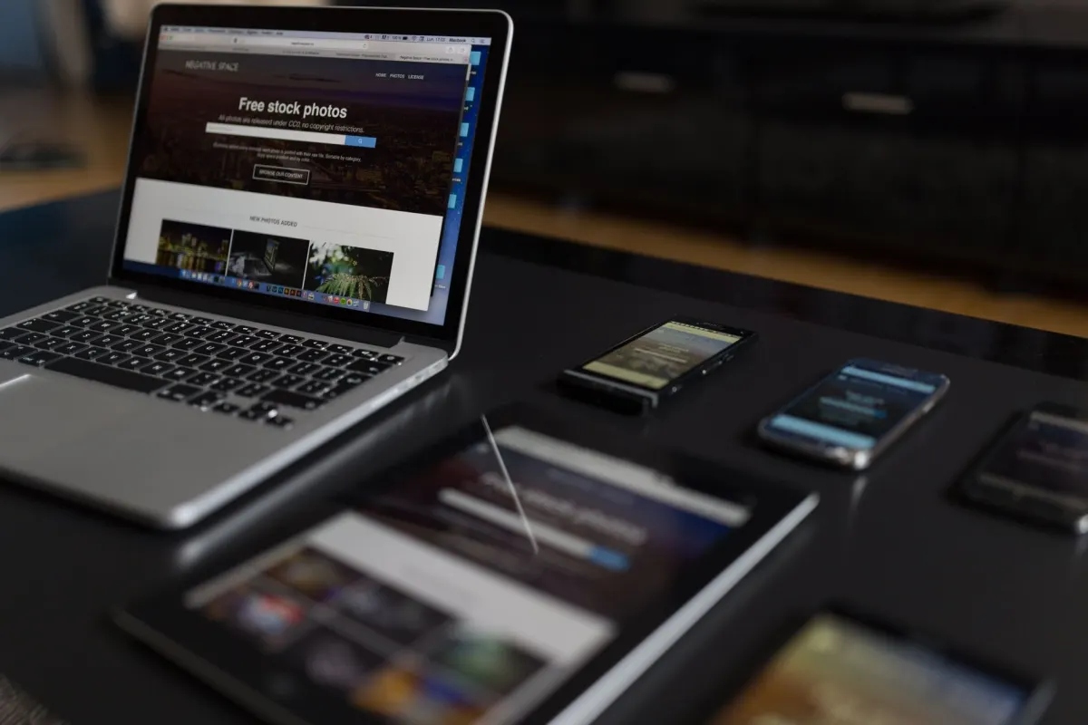 Mehrere Geräte, ein Laptop, ein Tablet und ein Smartphone, liegen zusammen und spiegeln die Geräte- und Browserdaten wider, die GA4 für jeden Besucher erfasst.