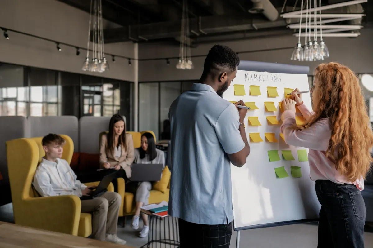Uma equipe de marketing organiza pontos de contato em um quadro branco, o tipo de sessão em que um modelo de atribuição transforma essas anotações em porcentagens.