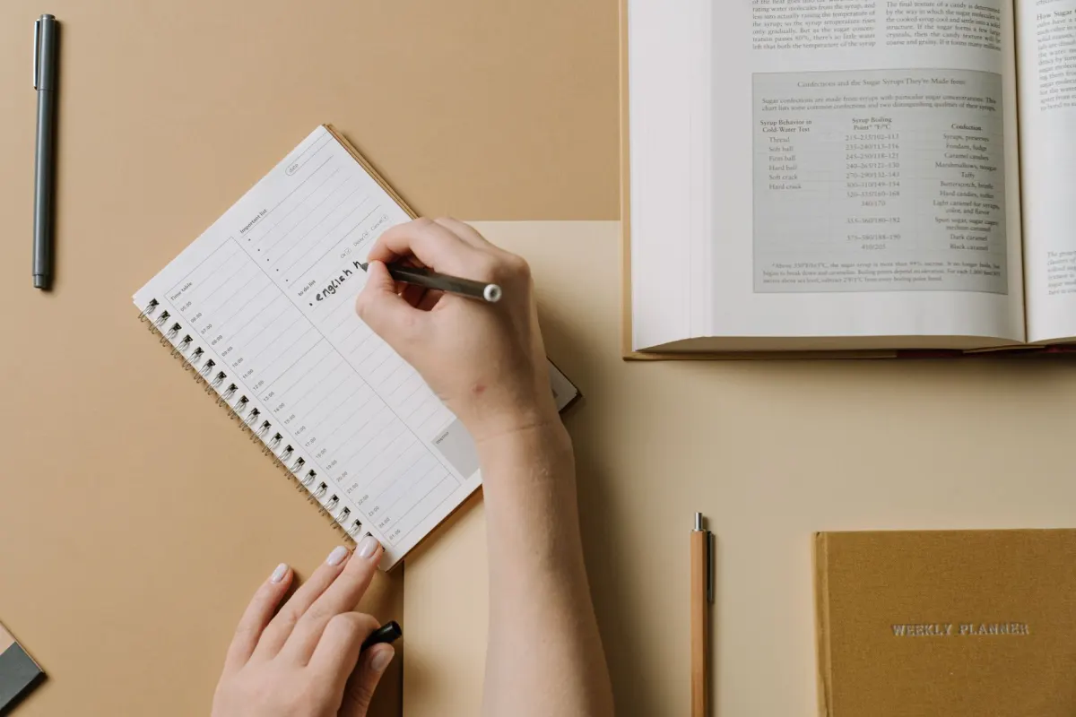 Una persona marca fechas en una agenda semanal, en línea con la necesidad de indicar rangos de fechas exactos y una zona horaria para cada periodo del informe.