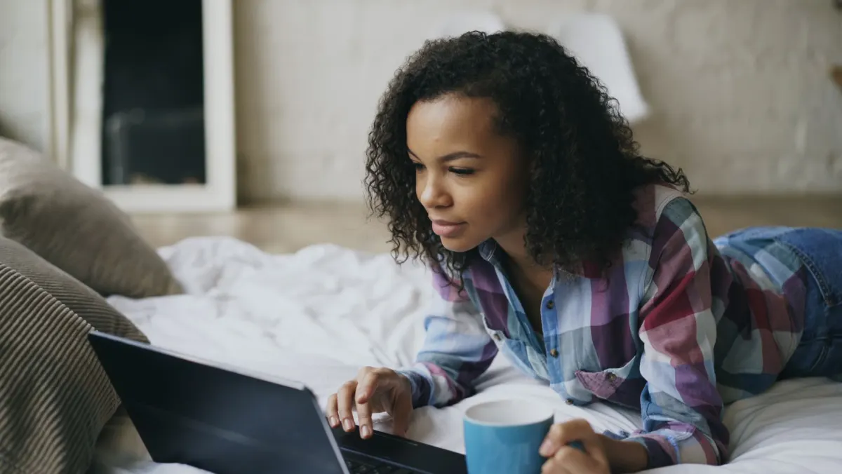 Jemand surft allein zu Hause am Laptop, eine Erinnerung daran, dass Besucher gemeinnütziger Websites oft private Gründe haben.
