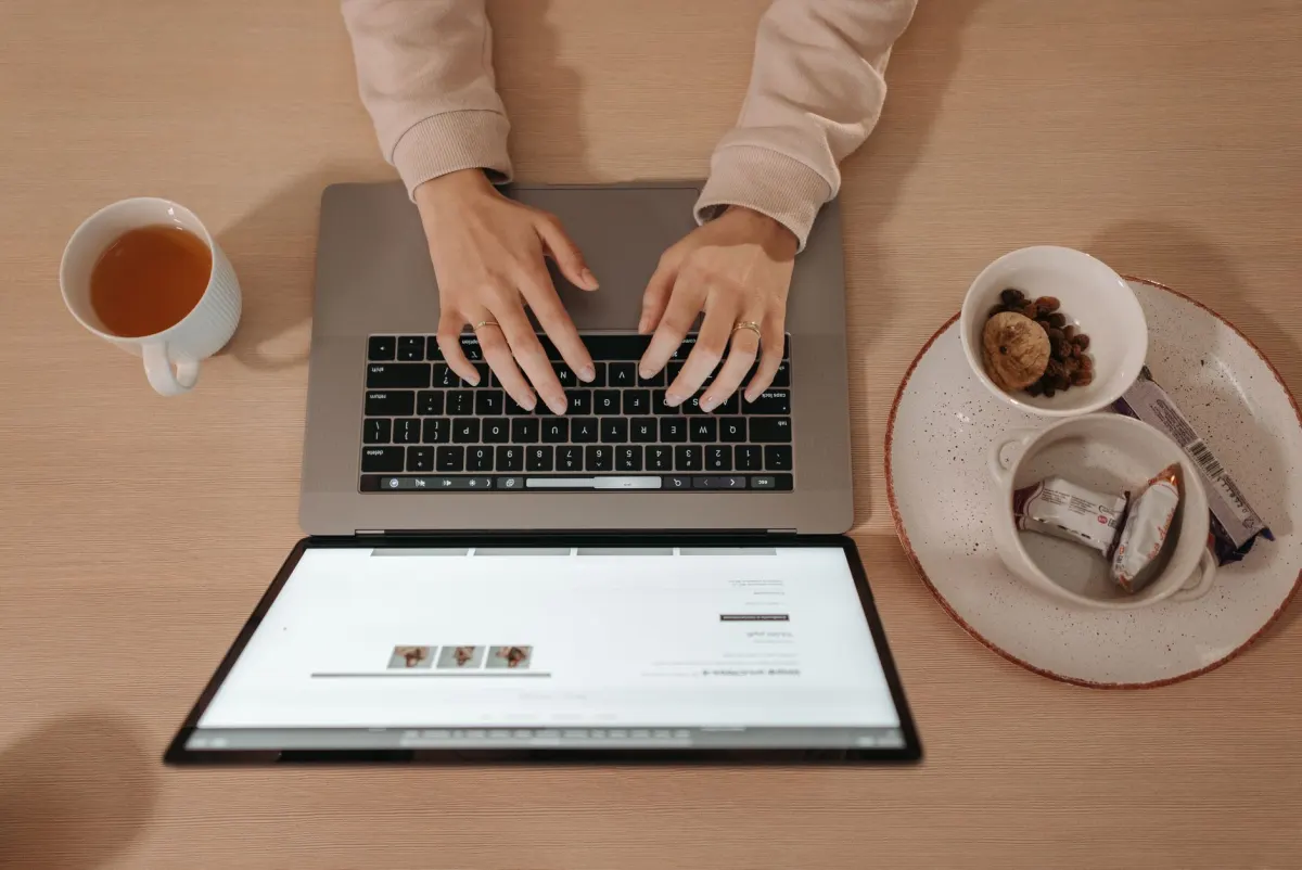 Una mano se detiene sobre el trackpad de un portátil frente a una ventana de consentimiento de cookies, mostrando el momento en que se toma o se omite una decisión de privacidad.